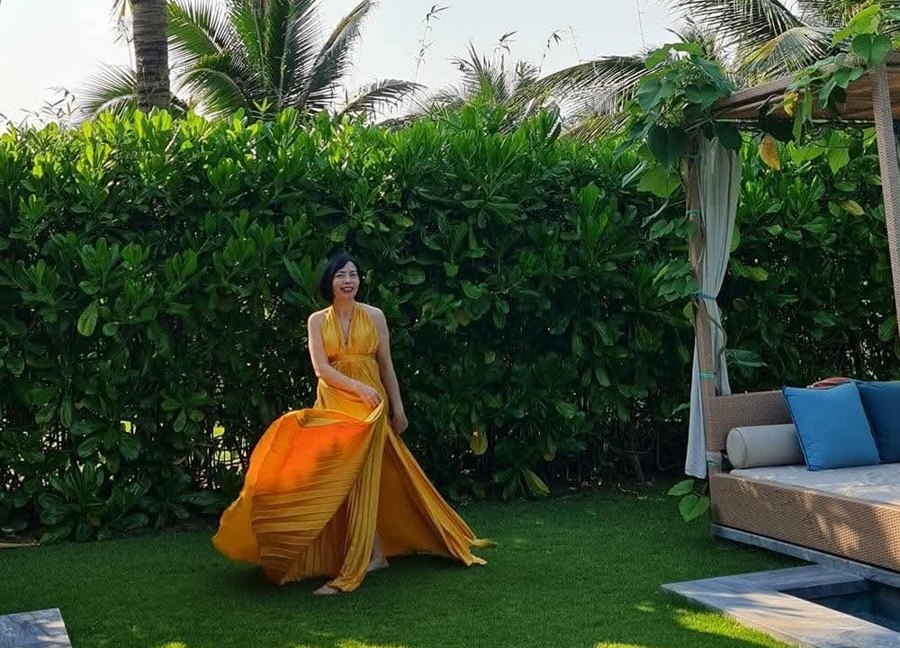 Cô Vũ Cần rạng rỡ trong chiếc váy vàng giữa khu vườn